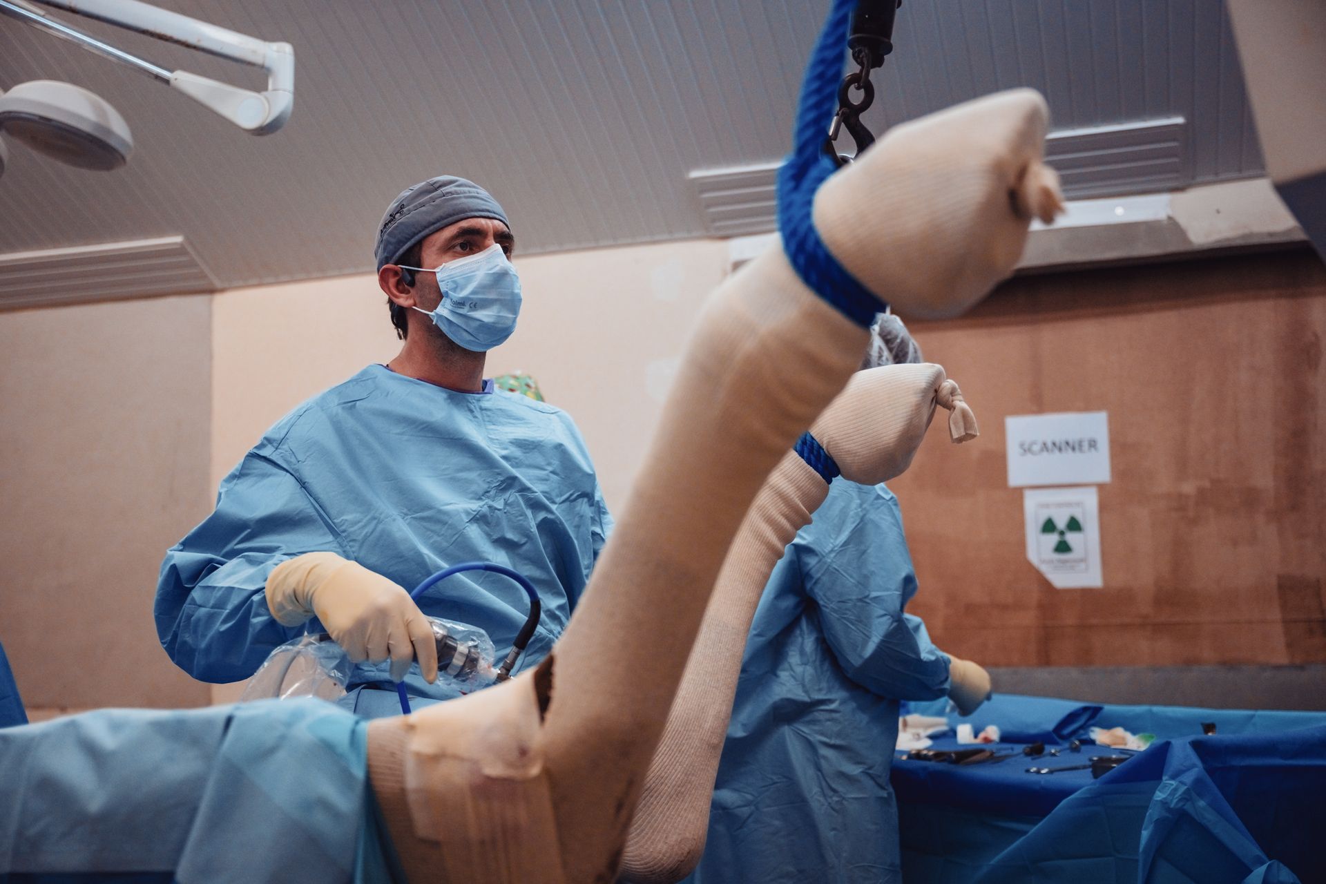 Un chirurgien opère la jambe d'un patient dans une salle d'opération.