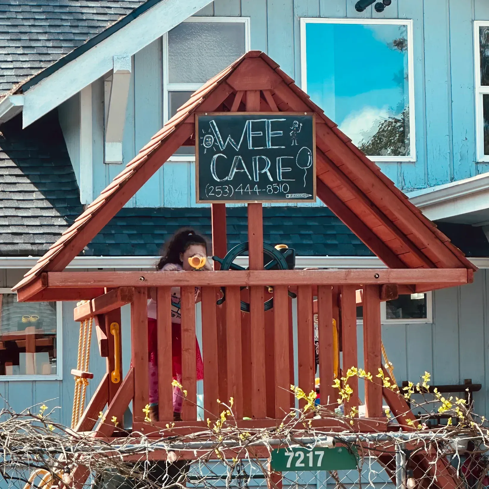 Girl in a wooden playhouse with 
