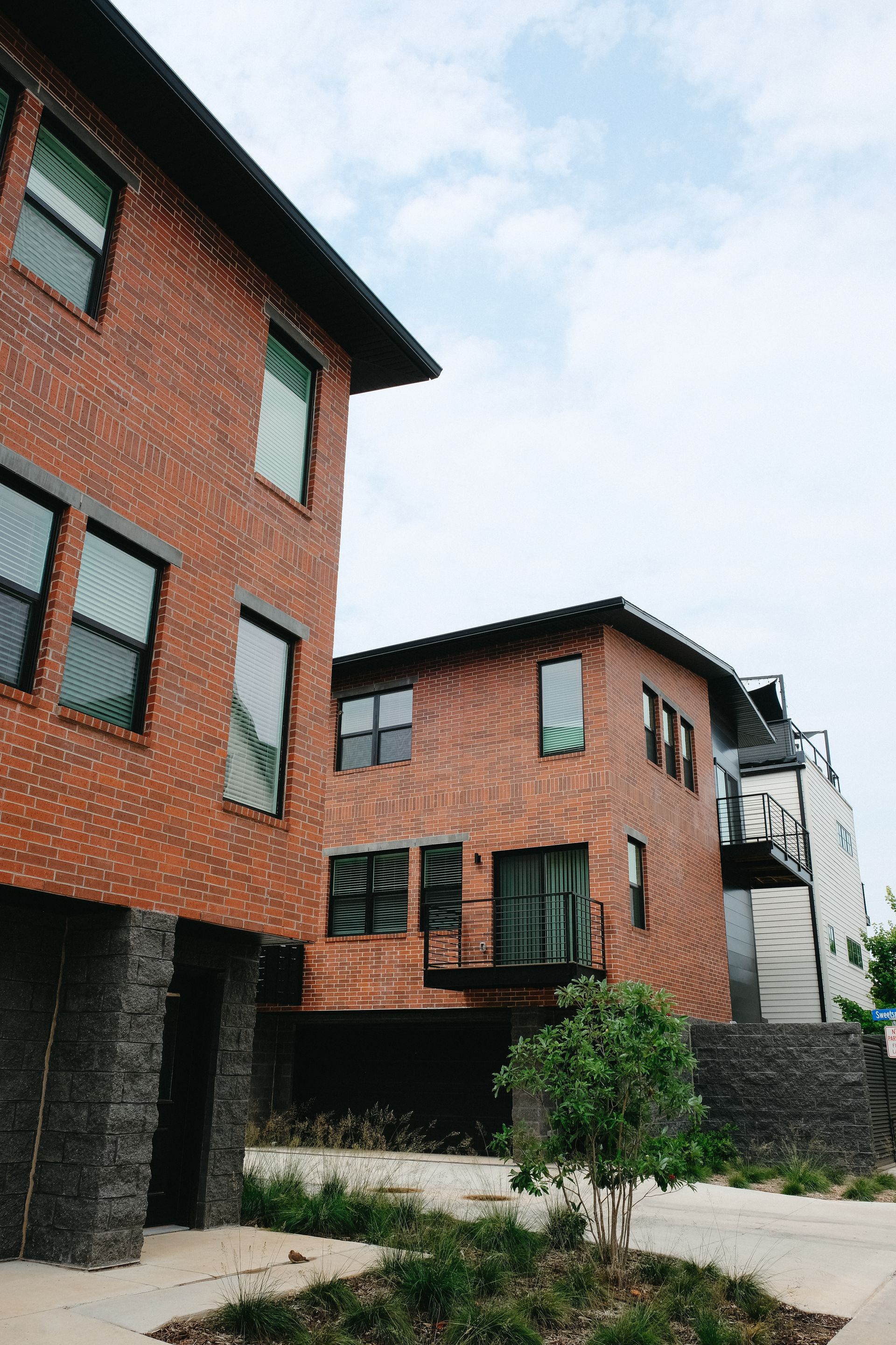 A brick building with a lot of windows is next to another building.