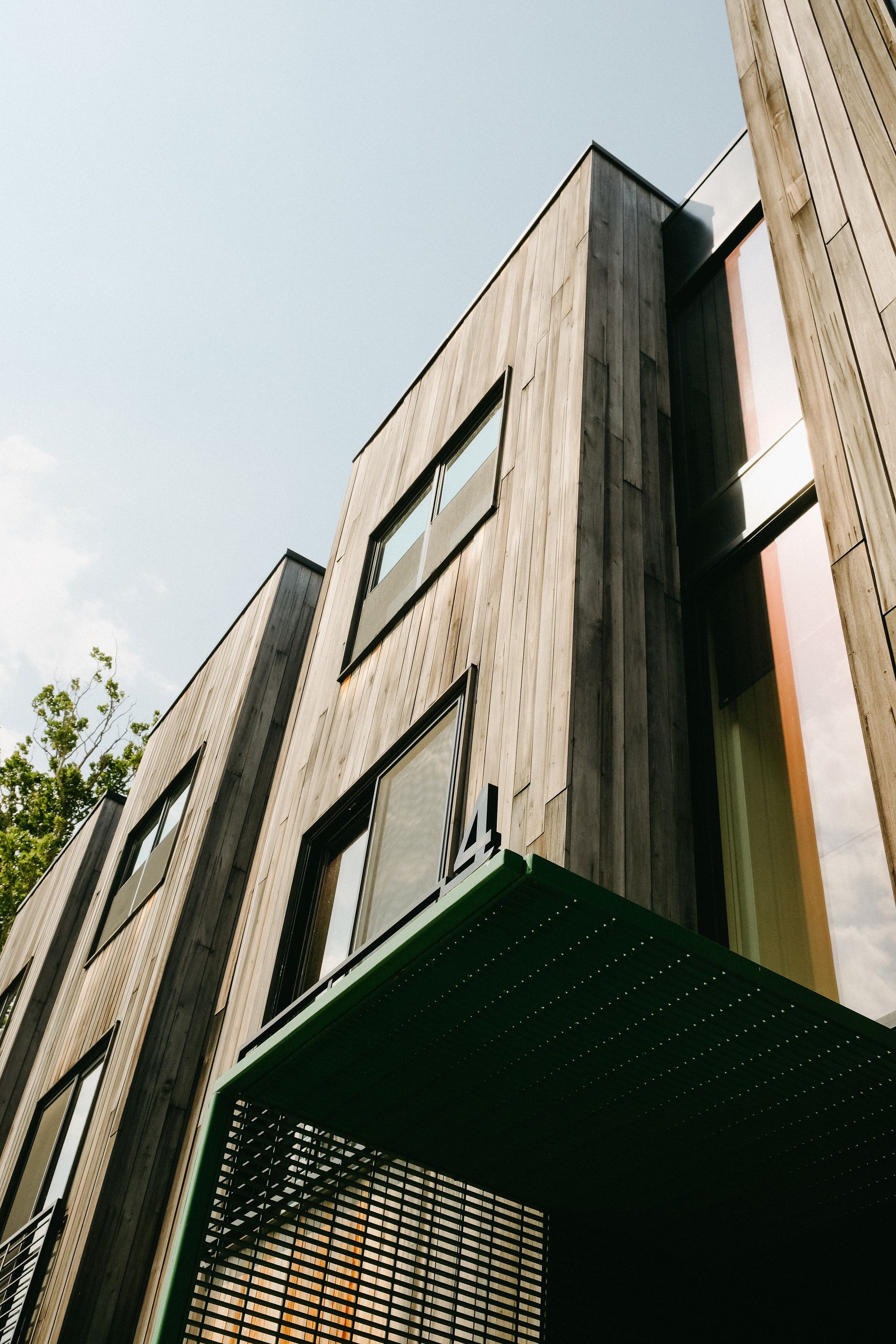 Wooden building exterior with green metal awning, blue sky.