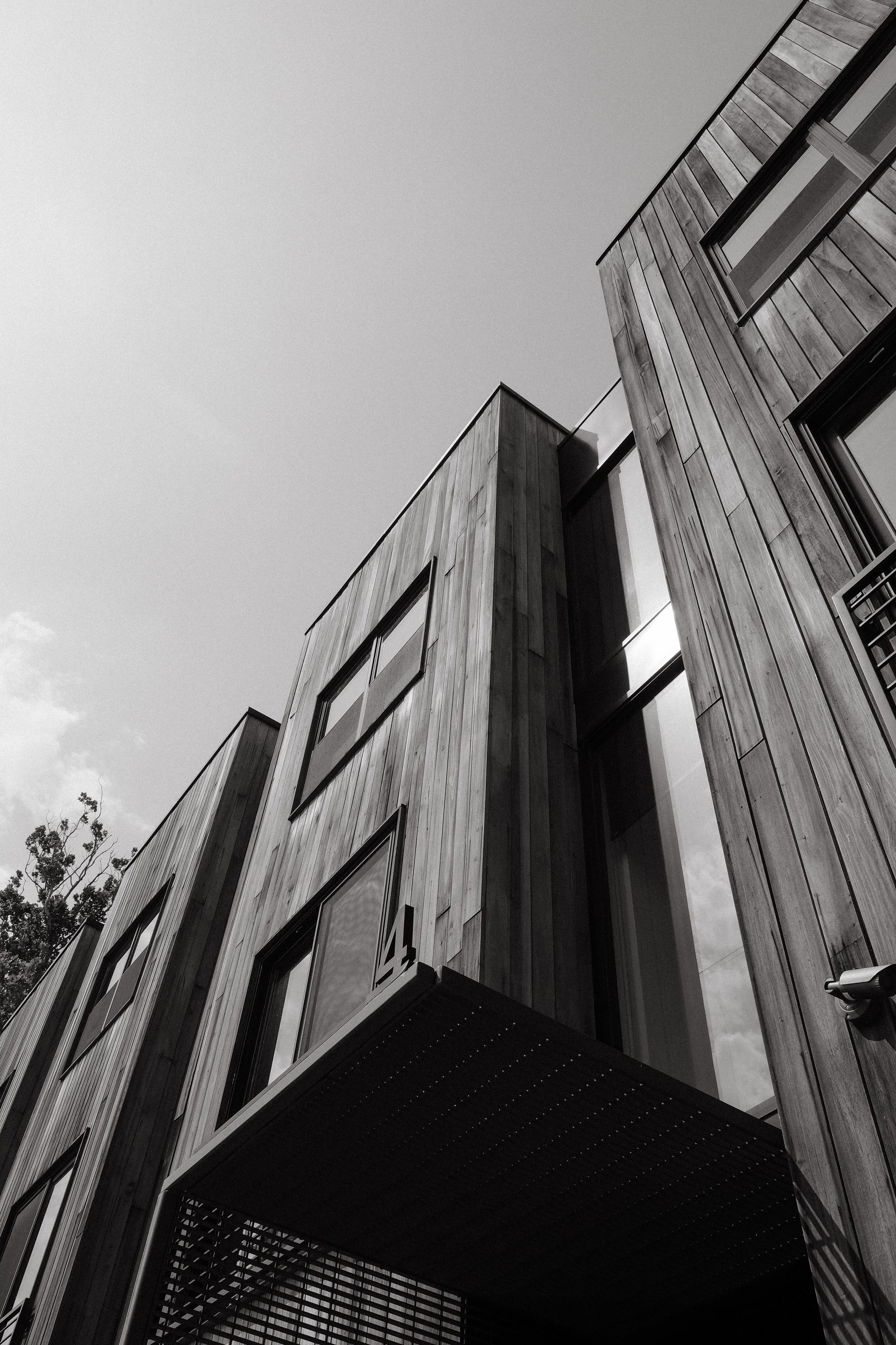 Modern wooden building with large windows, angled view.