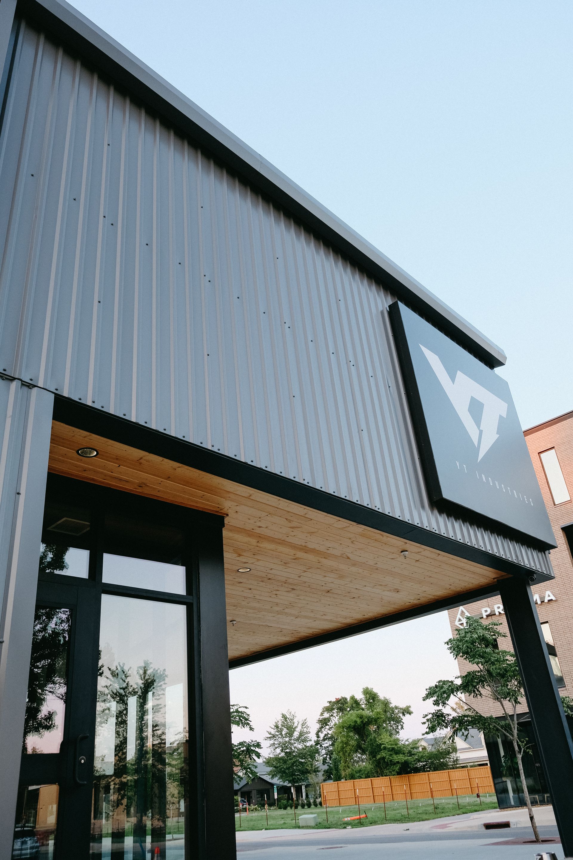 Modern building exterior with a logo, glass doors, and black accents.