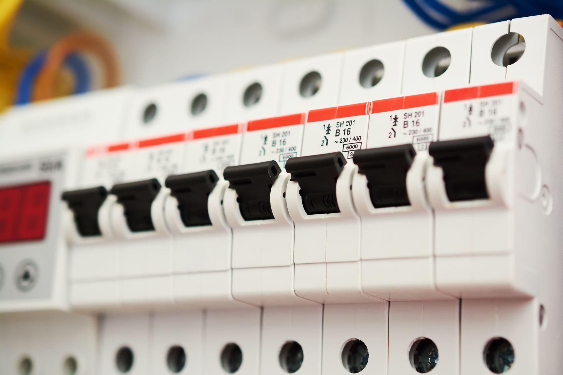 Row of white electrical circuit breakers with black switches in a control panel
