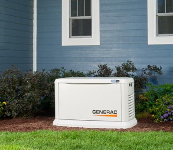 White Generac home generator beside a blue house and shrubs on a grassy lawn