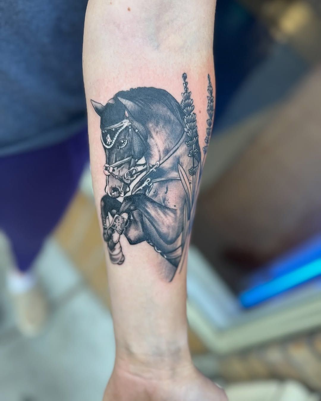 A person has a tattoo of a horse on their arm
