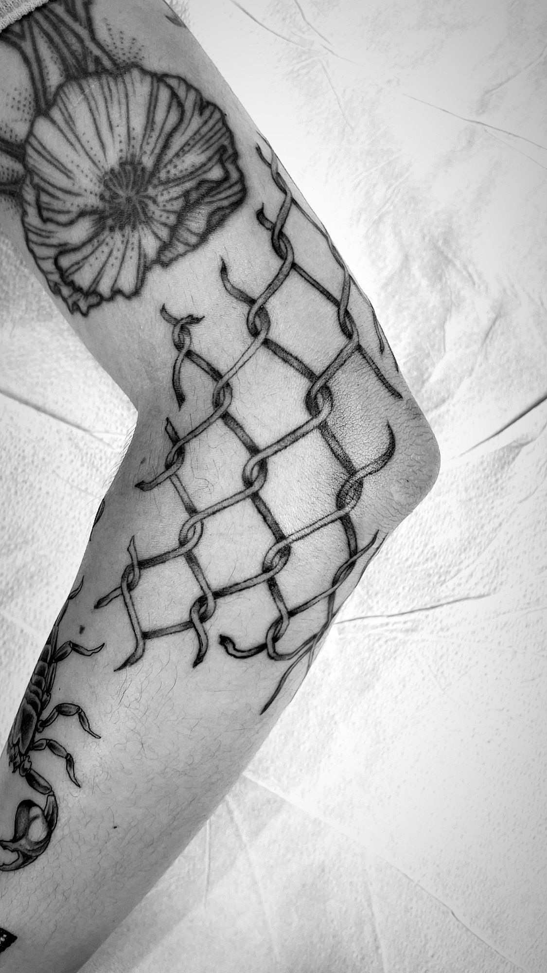 A black and white photo of a tattoo on a person 's arm.
