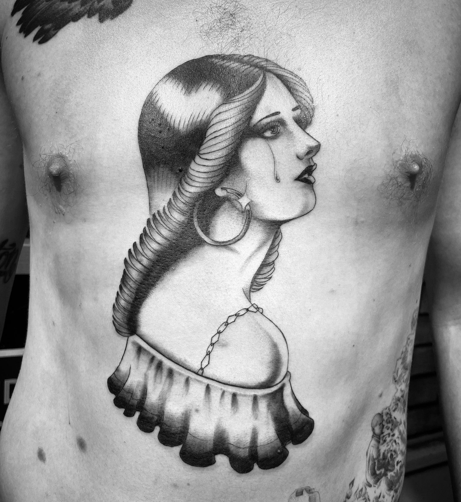 A man has a tattoo of a woman 's face on his chest
