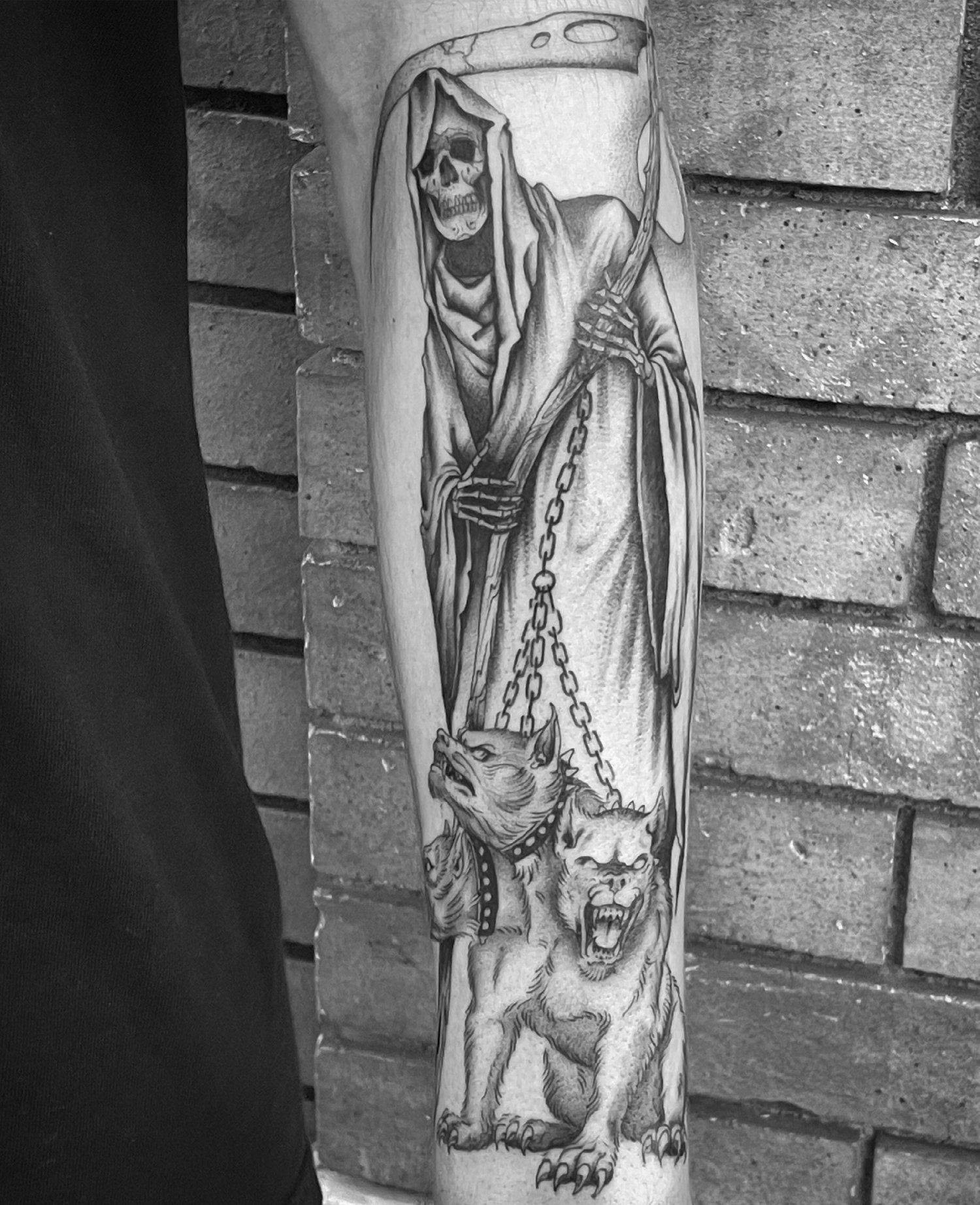 A man has a grim reaper tattoo on his arm