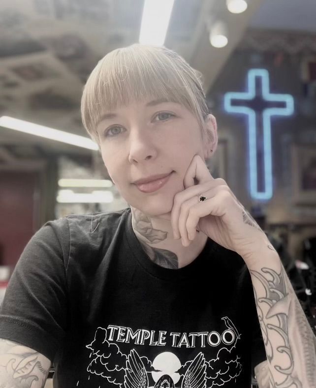 A woman has a tattoo on her neck that looks like a necklace