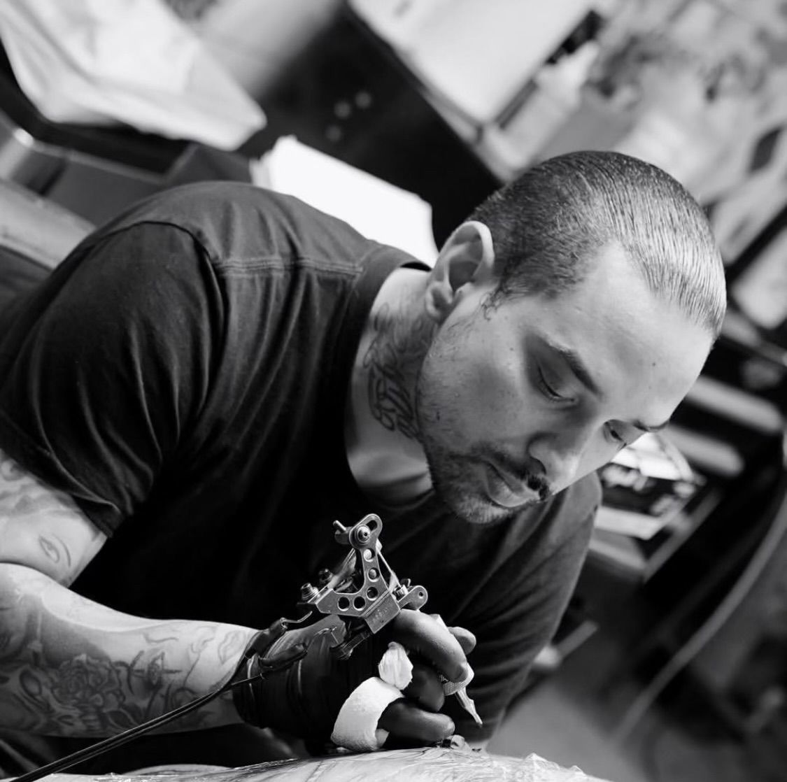 A man has a tattoo of bob marley on his leg.