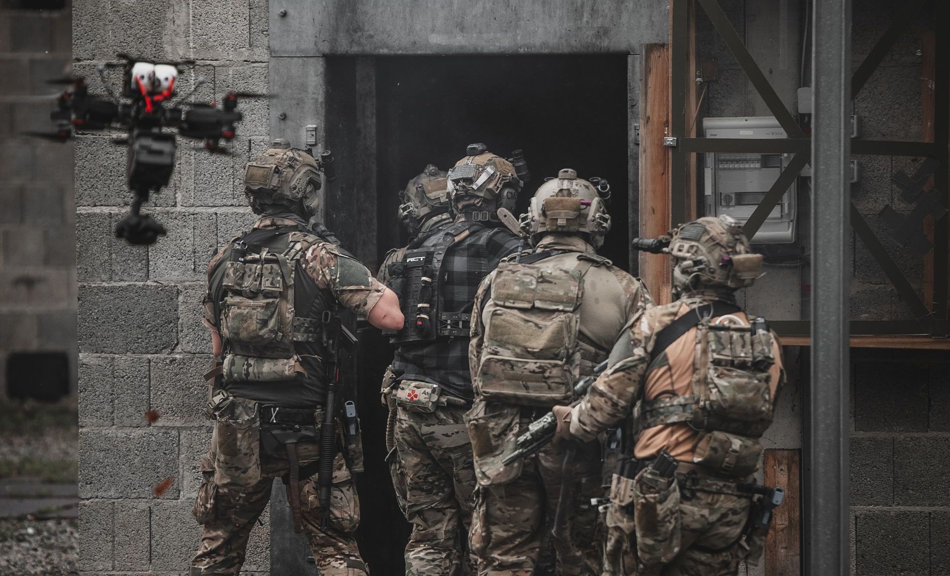 Tactical performers enter a house while a WarpCam® FPV drone films.