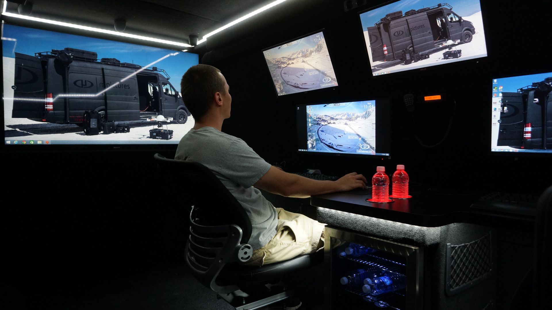Mobile command center interior with modular workstations and swivel seats.