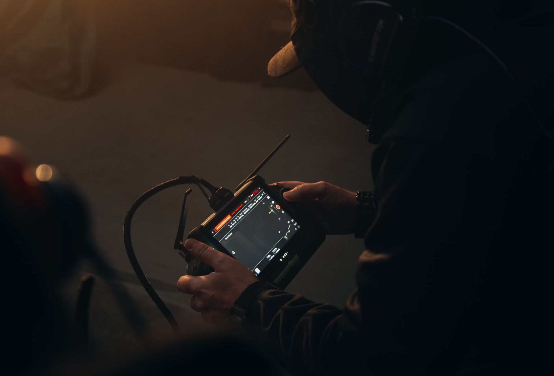 view of Ferdi Fischer operating the WarpCam® system, focused on adjusting settings on the camera control panel.