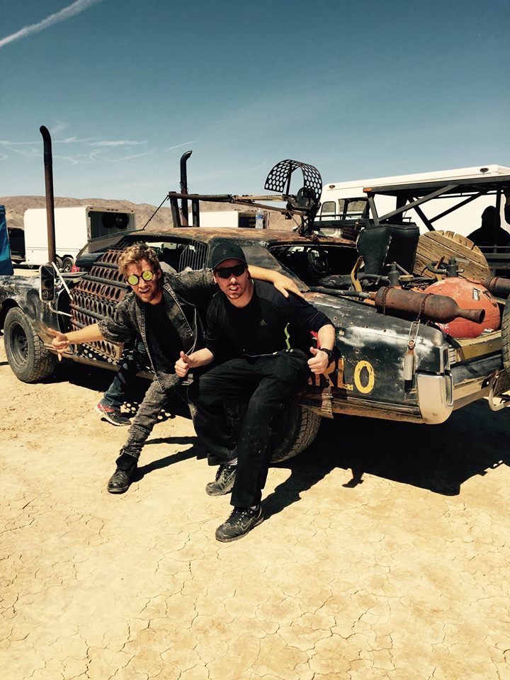 Ferdi Fischer with another stunt performer and modified vehicles on a Nevada dry lakebed.