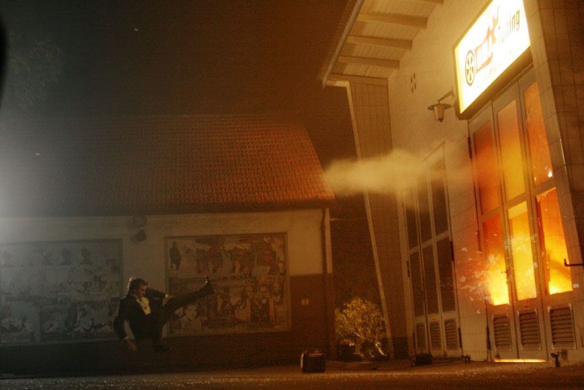 Ferdi Fischer suspended midair as flames and debris burst through a garage door.