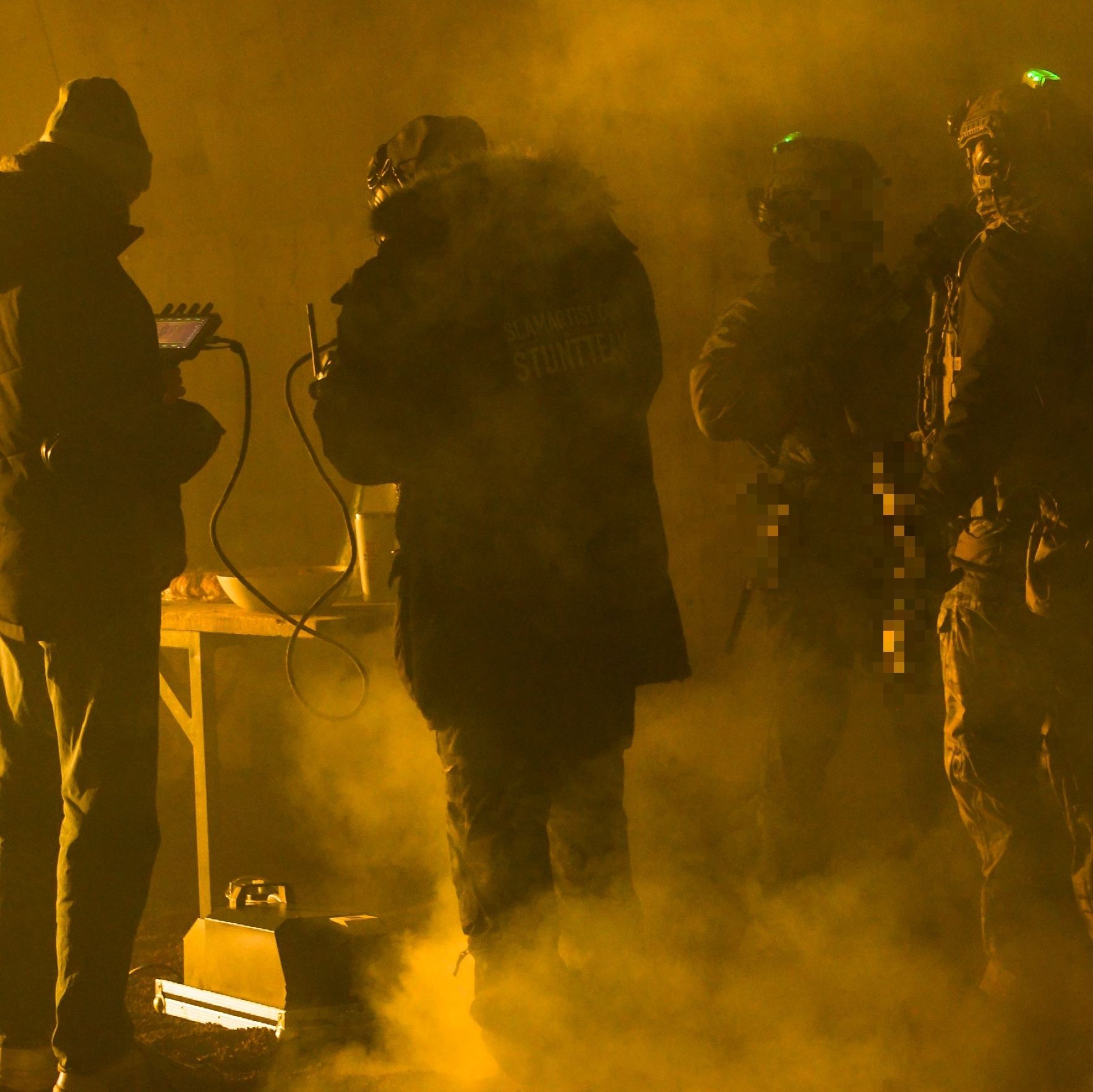 Ferdi Fischer briefing tactical performers on a smoke-filled night film set.