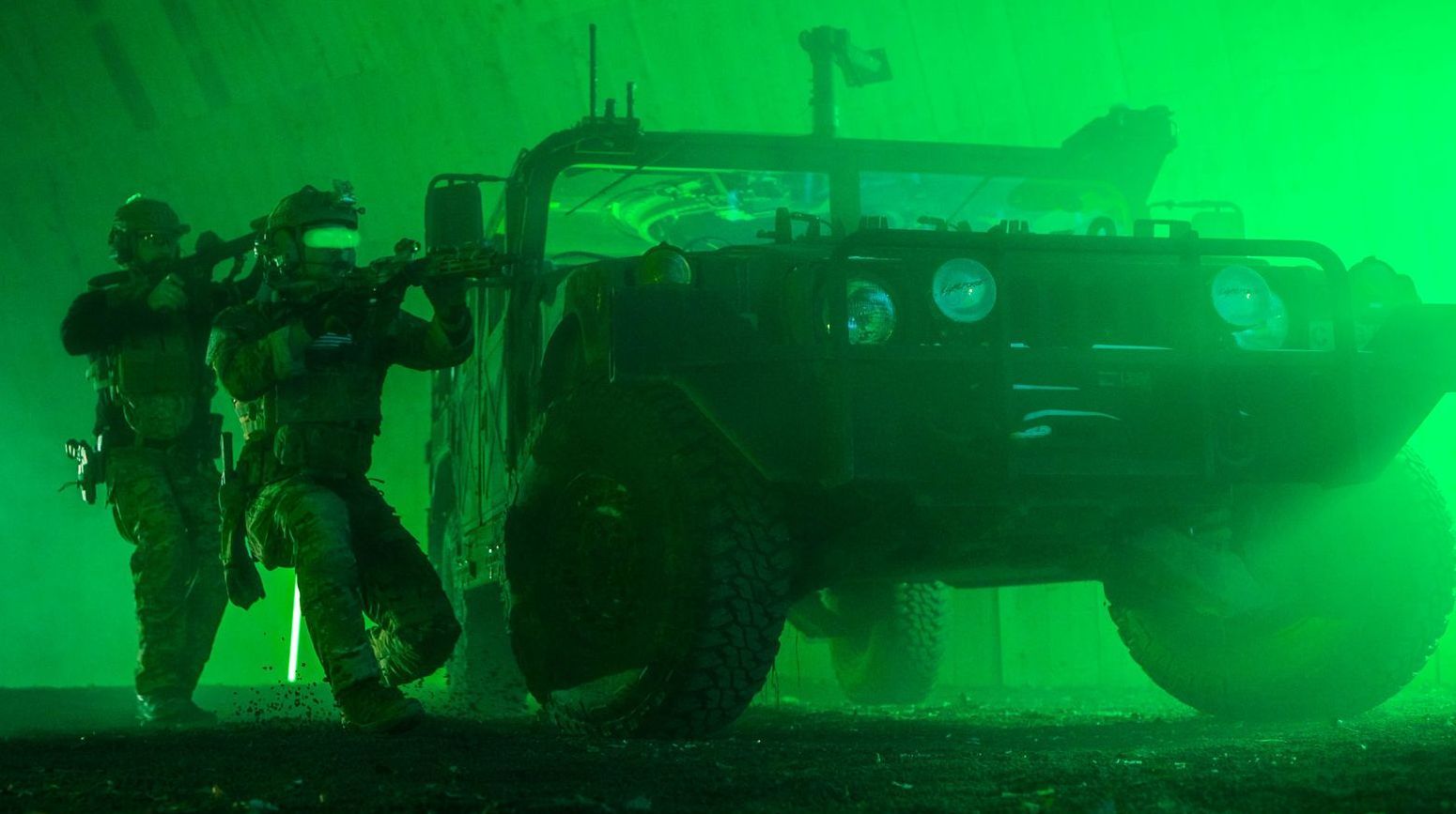 Two tactical performers taking cover behind a Humvee during filming.