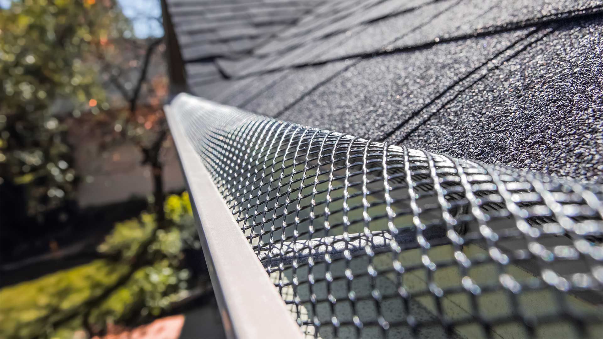 A close up of a gutter with a gutter guard on it.