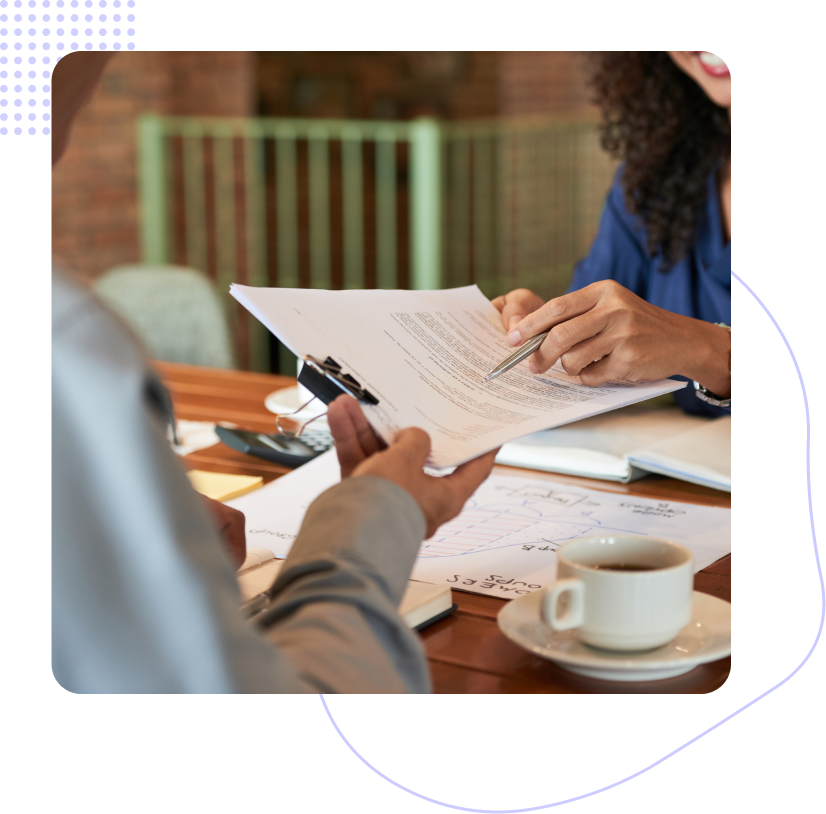 Two people are sitting at a table looking at a piece of paper.