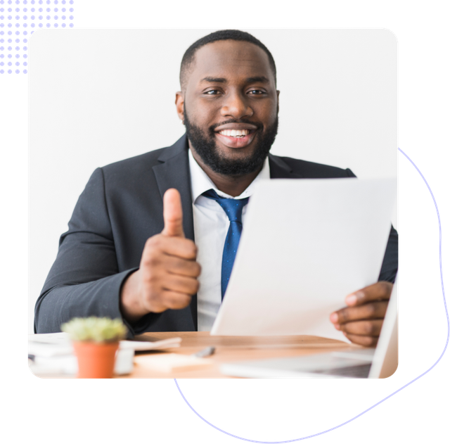 A man in a suit and tie is giving a thumbs up while holding a piece of paper.