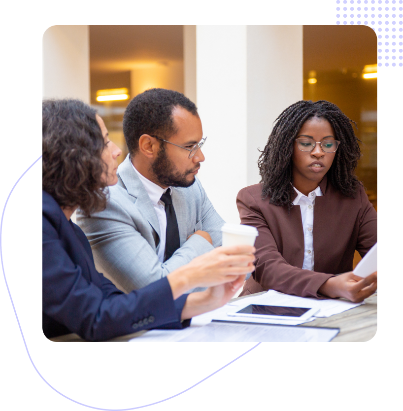 A group of people are sitting at a table having a meeting.