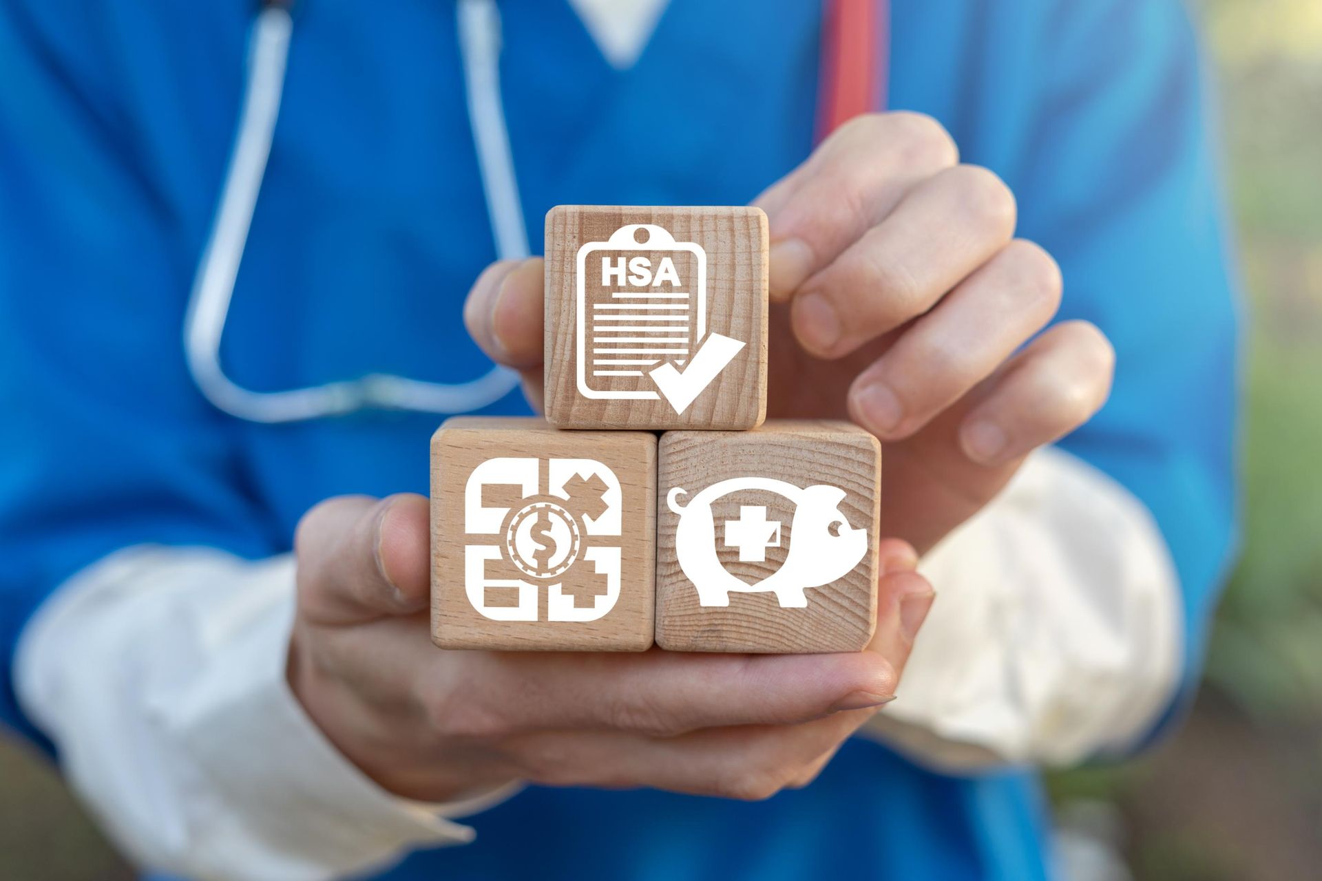 A doctor is holding a stack of wooden blocks with icons on them.