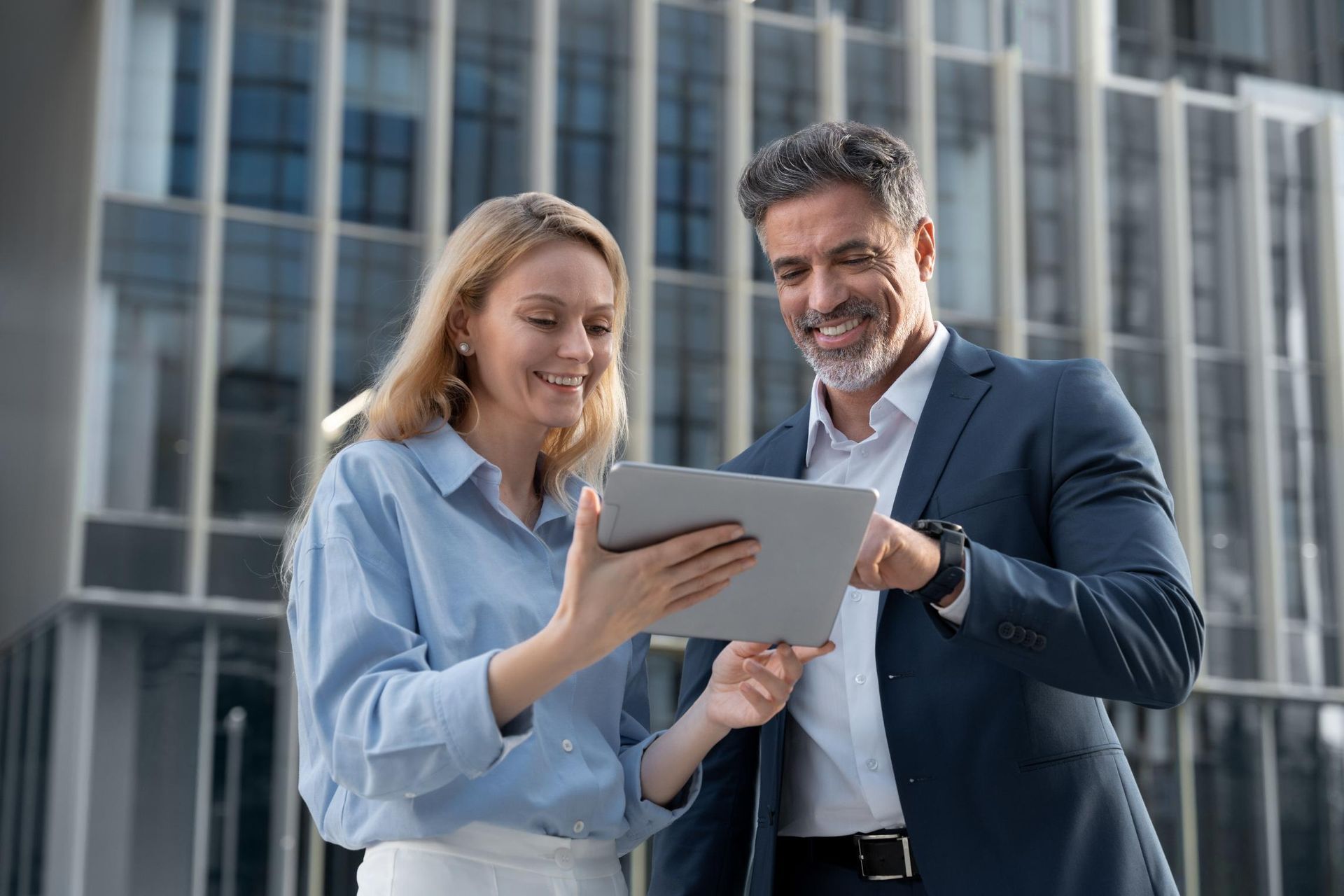 A man and a woman are looking at a tablet together.