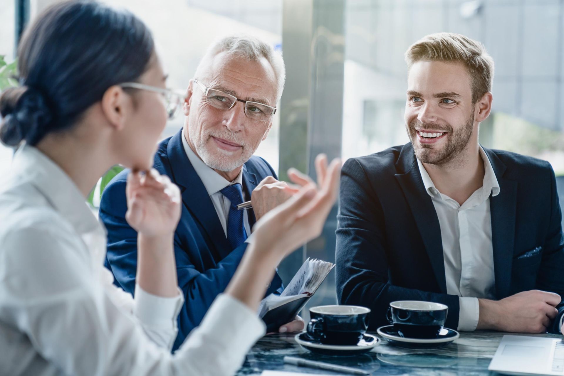 A group of business people are sitting at a table having a meeting.