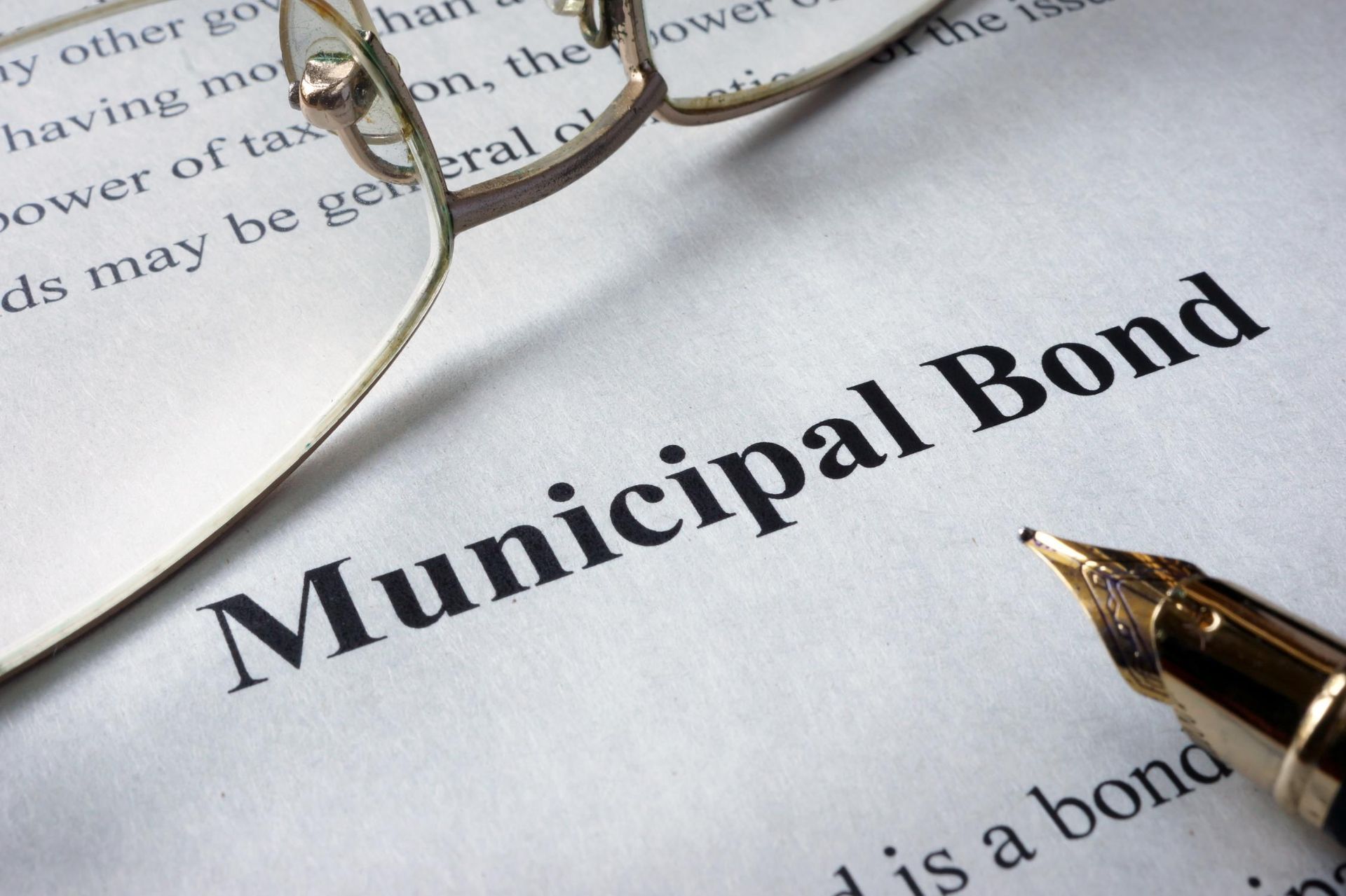 A pair of glasses sit on top of a piece of paper that says municipal bond.