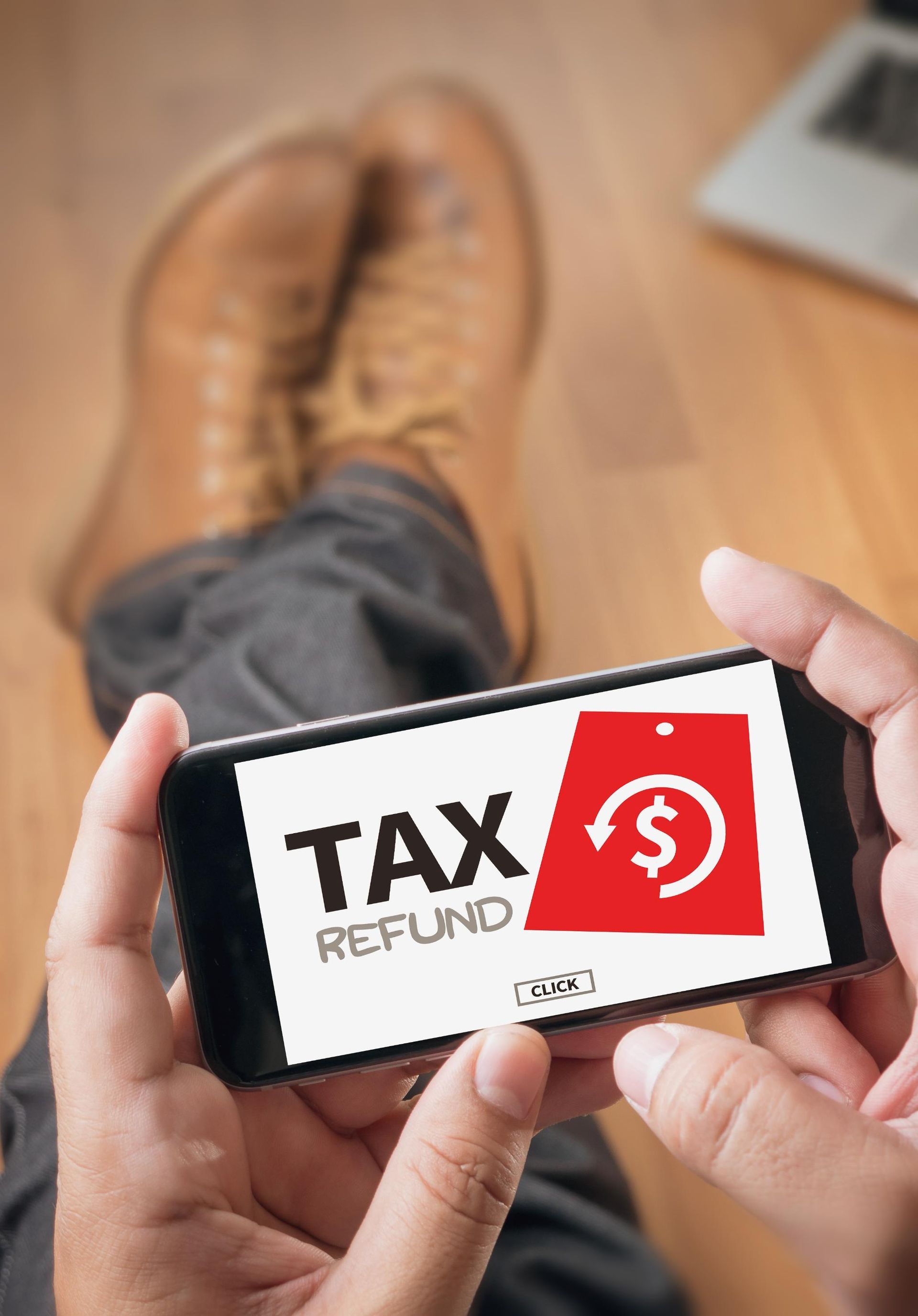 A person is holding a cell phone with a tax refund app on it.