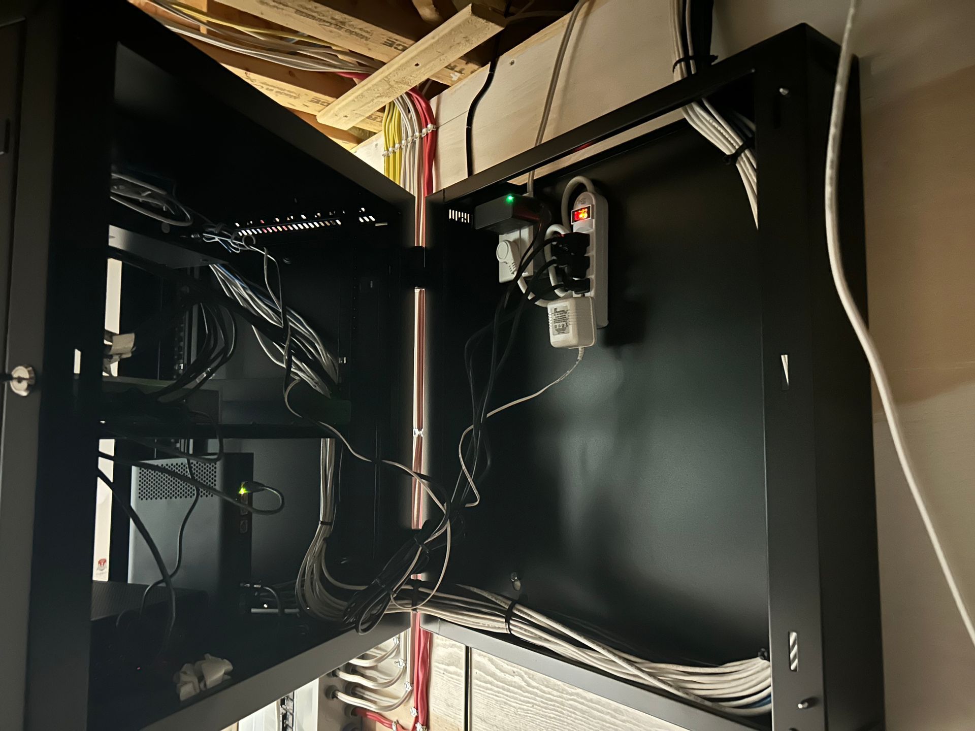 Une armoire noire avec un tas de fils qui en sortent