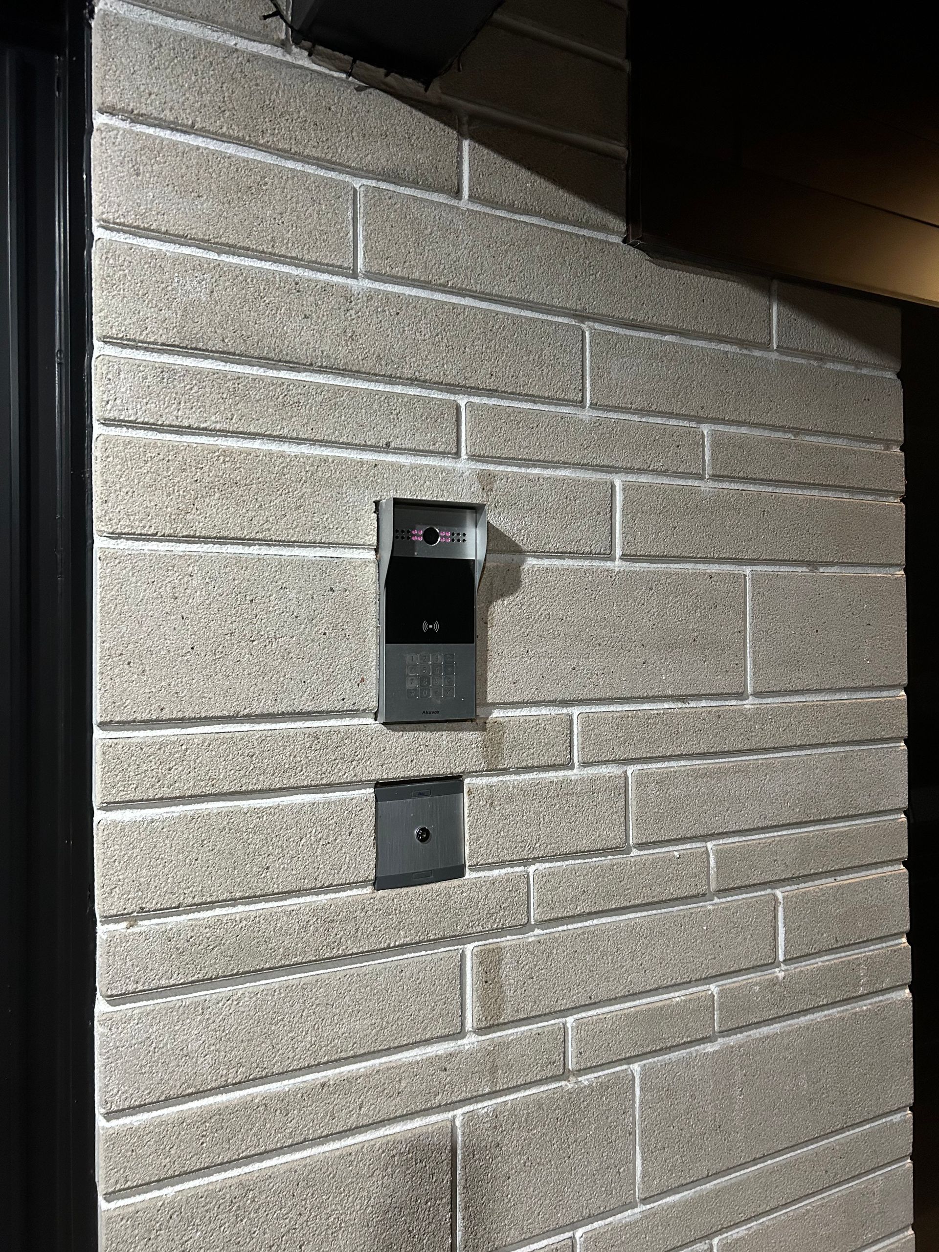Un mur de briques avec une sonnette dessus.