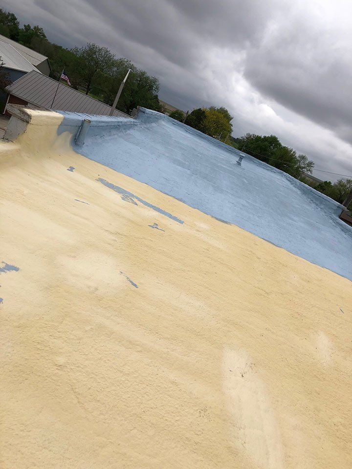 Blue And Cream Painting On Roof — Cedar Valley, IA — Raber Roofing Systems LLC.
