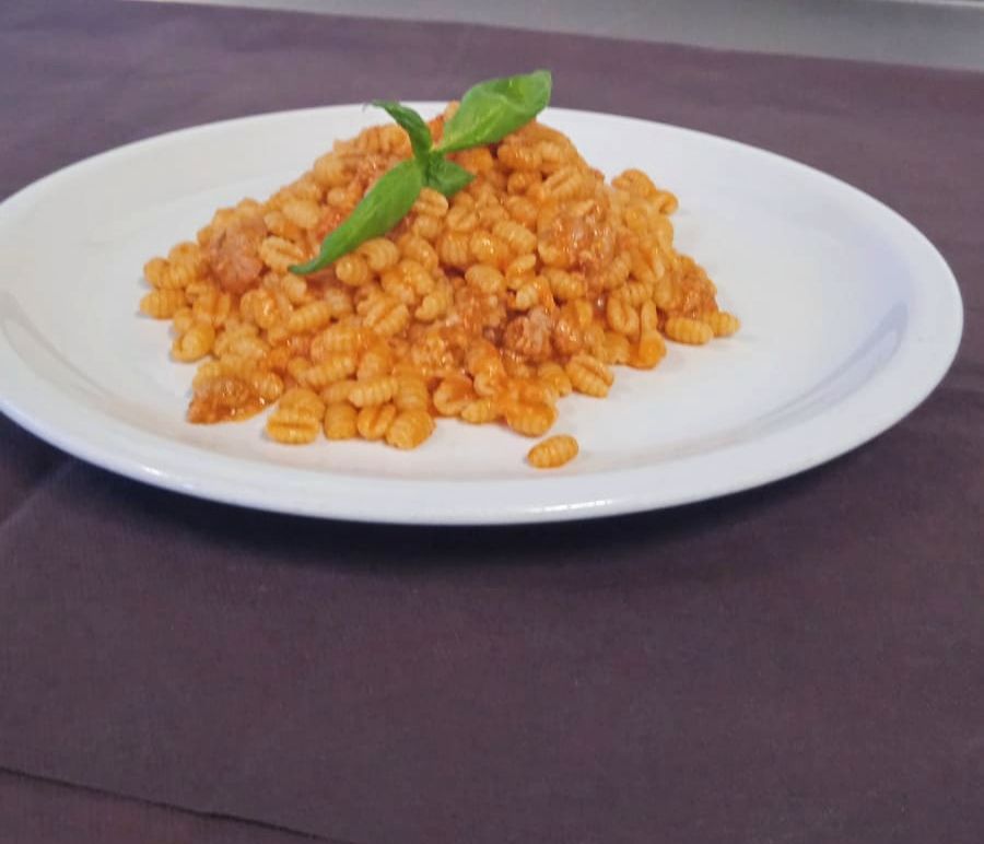 Piatto di riso arancione con un rametto di menta su un tavolo scuro