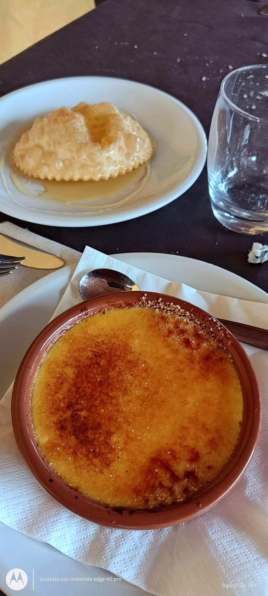 Due piatti da dessert su un tavolo di ristorante, tra cui una crema pasticcera caramellata e una pasta sfoglia