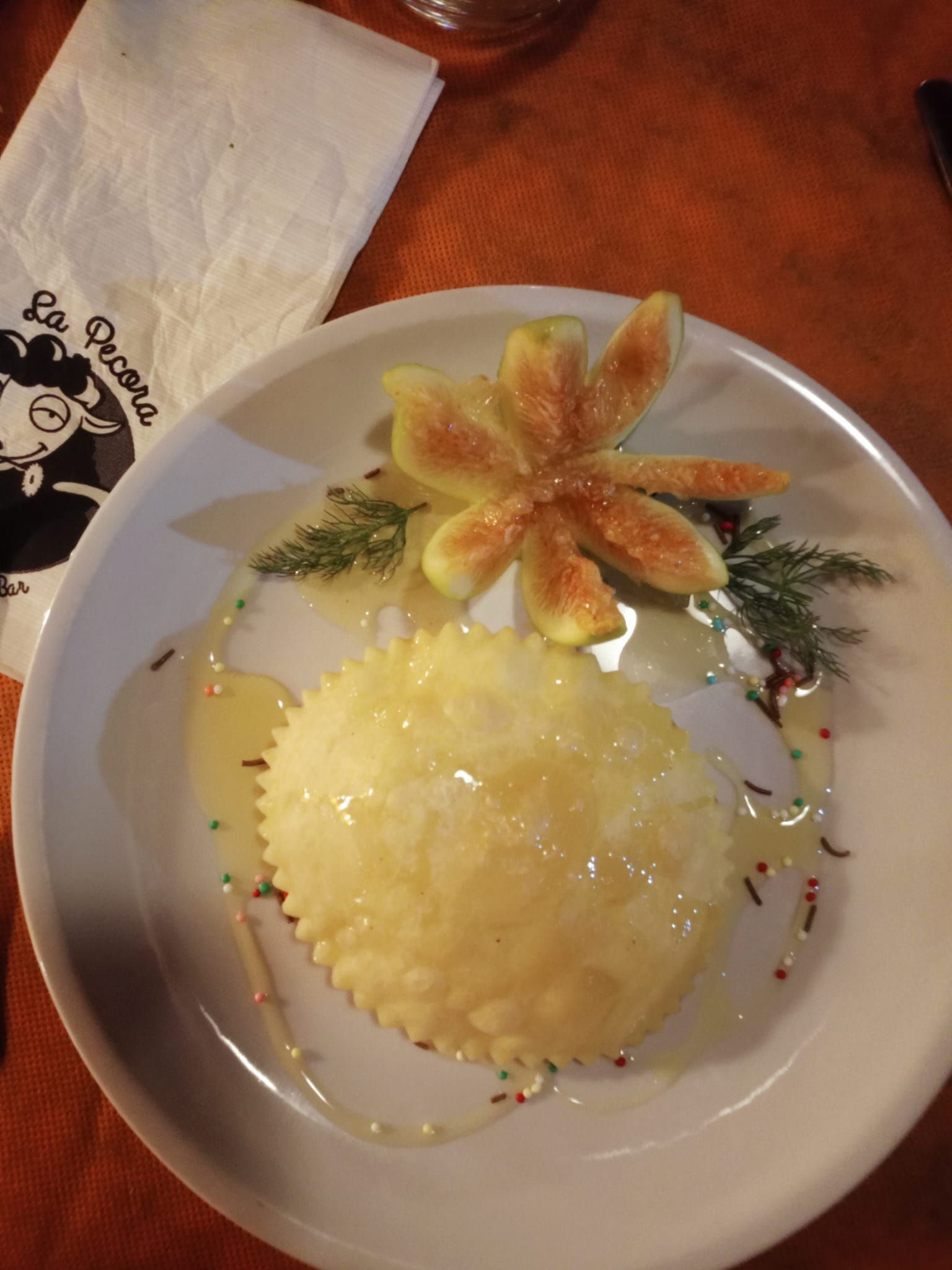 Piatto con un mucchietto di riso bianco e un fiore di guarnizione arancione su un piatto da fiori, su un tavolo di legno.