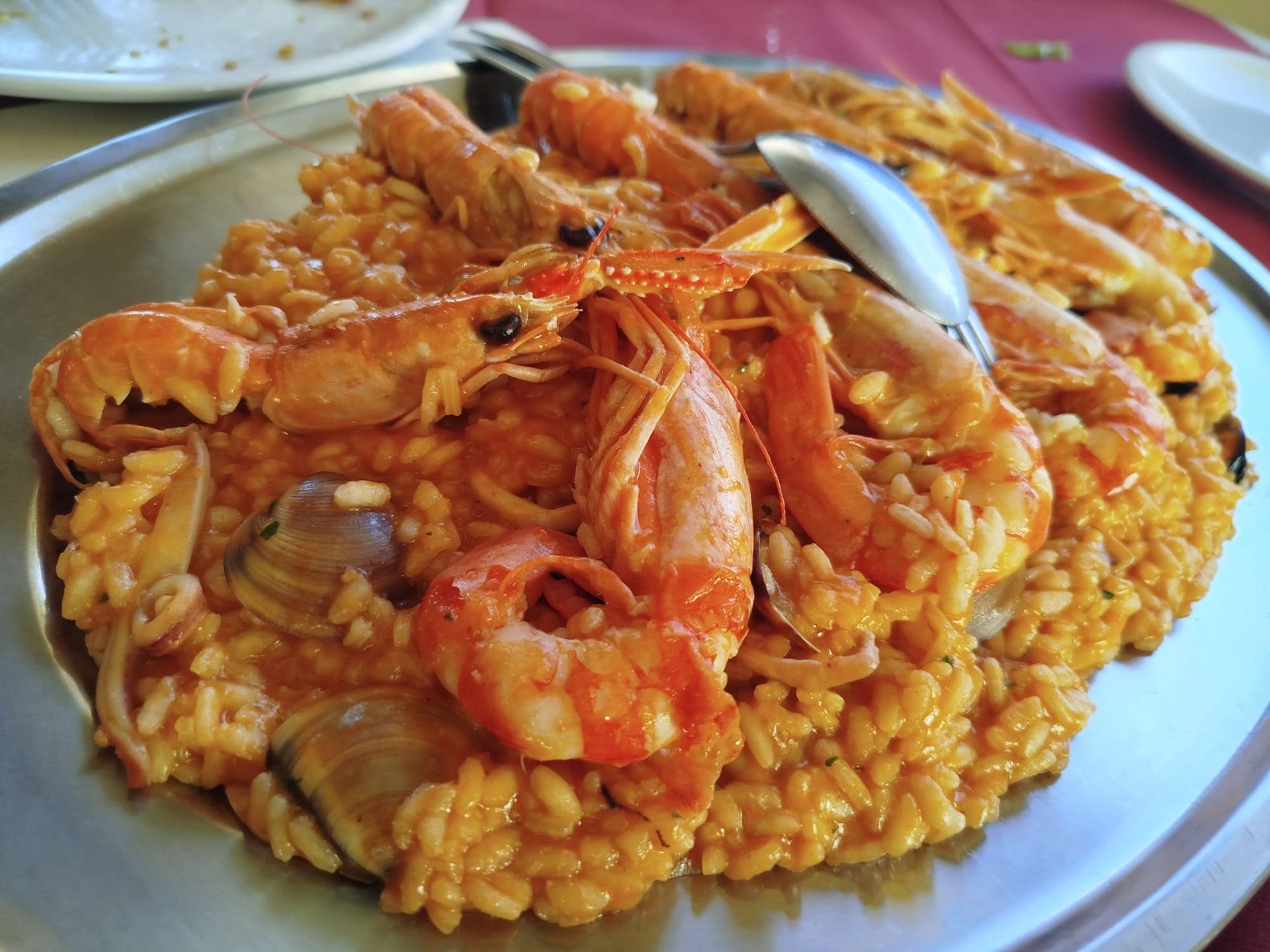 Paella di pesce con gamberi e cozze su un piatto bianco