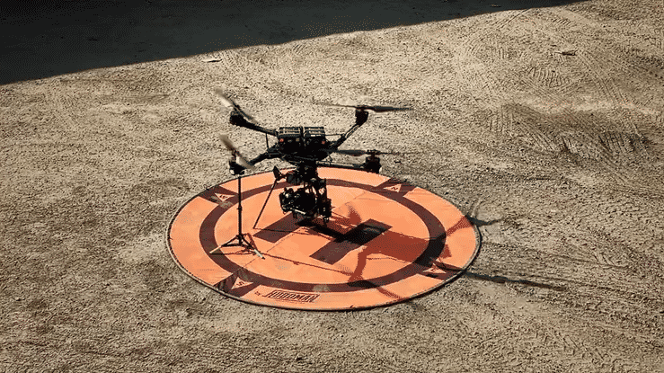 A drone is sitting on top of an orange circle on the ground.
