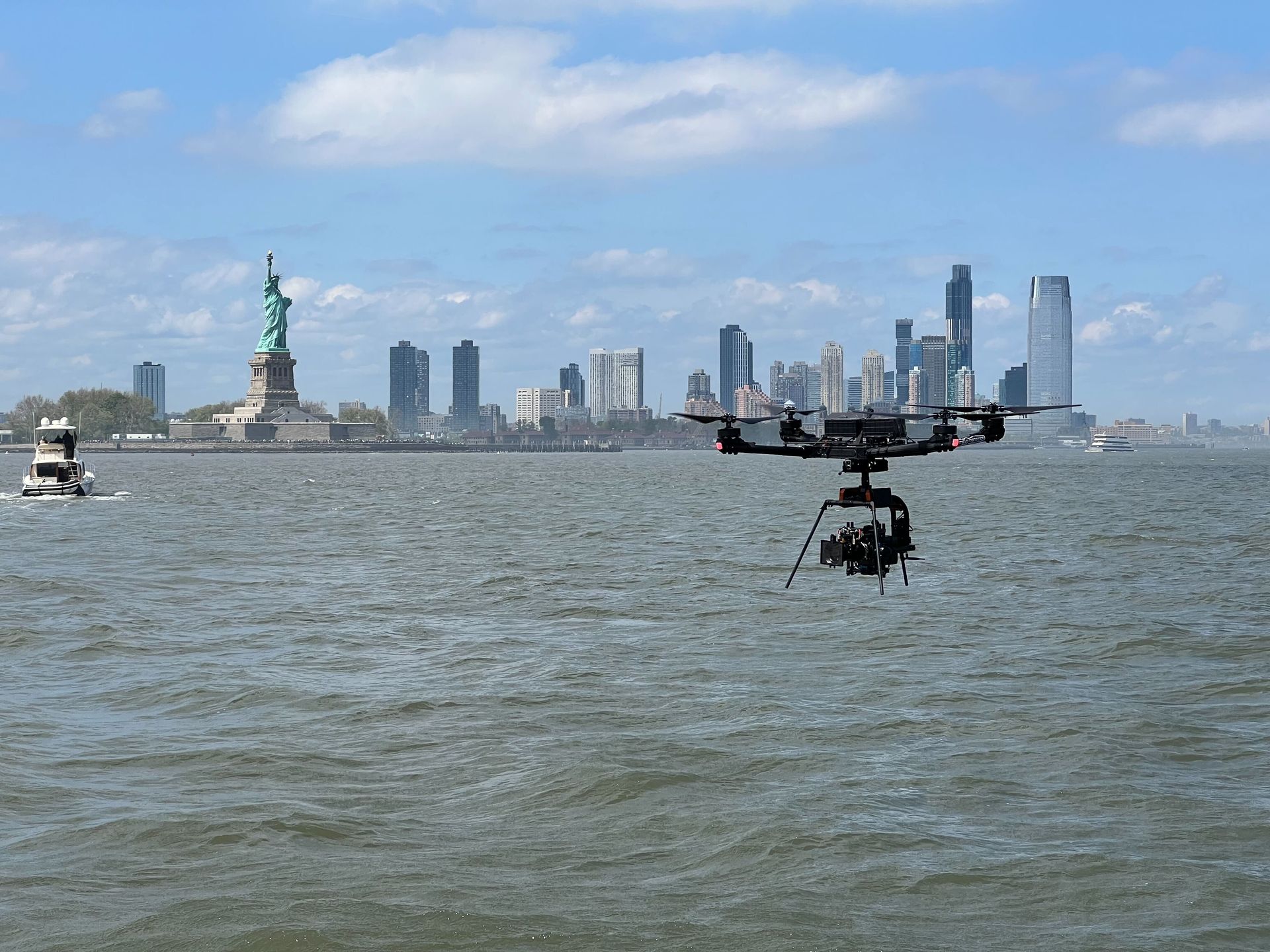 A statue of liberty is visible in the distance behind a large body of water