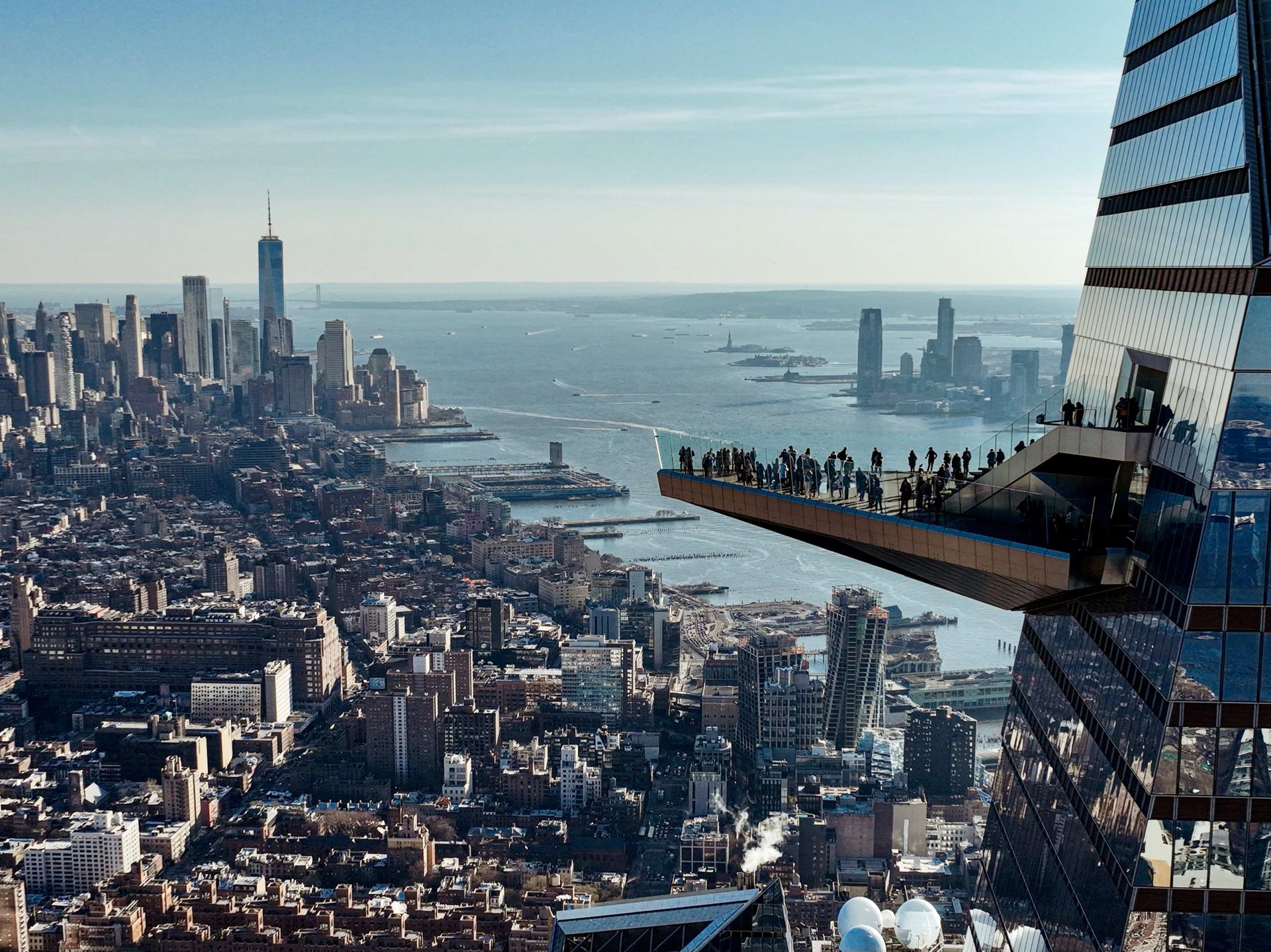 A group of people are standing on a platform overlooking a city.