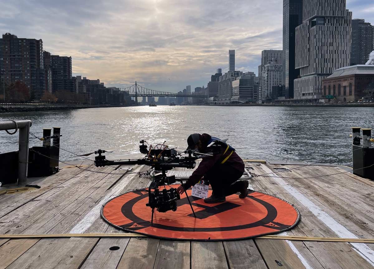 A man is kneeling on a dock near a body of water