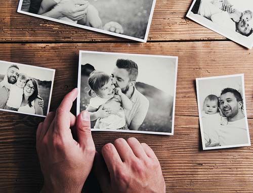 hands holding black and white photos