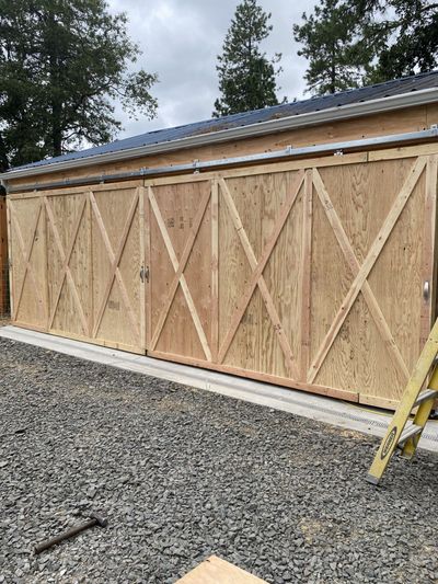 House exterior under construction with scaffolding and unfinished siding around the front entrance
