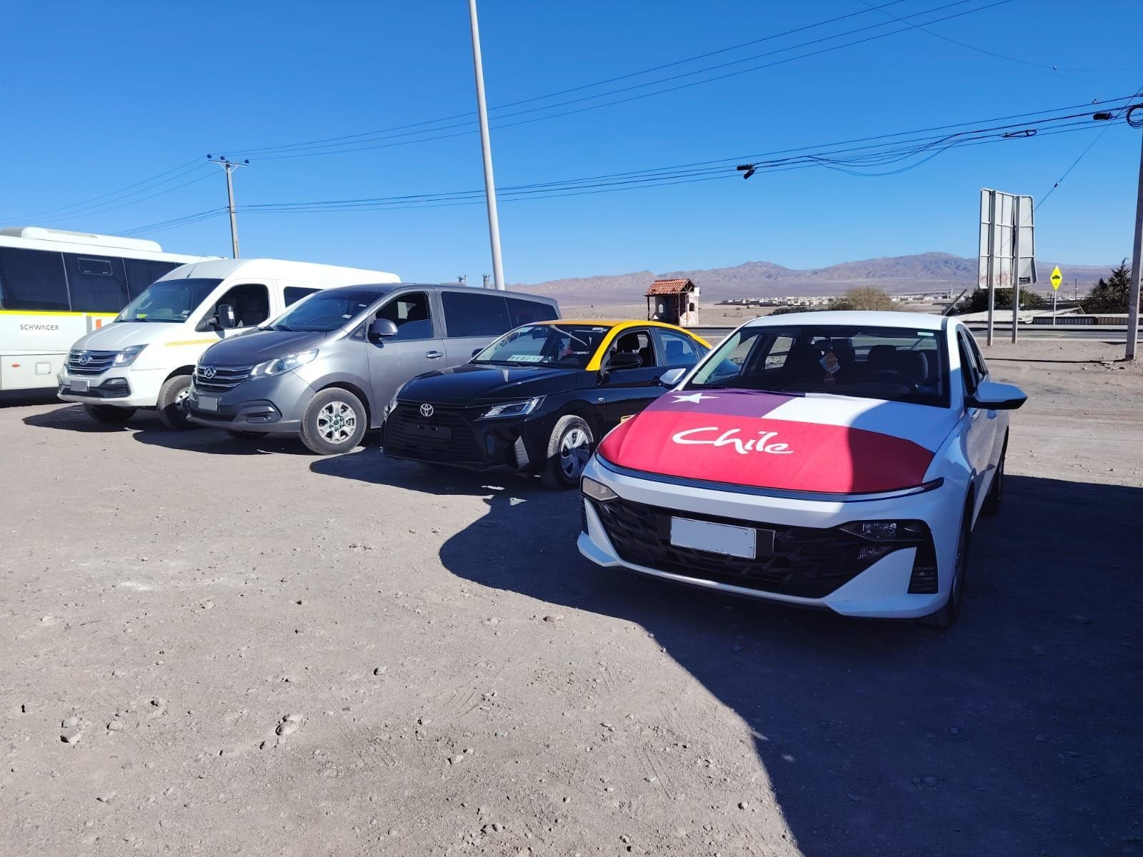 Una fila de vehículos, entre ellos un coche blanco con un letrero que decía 
