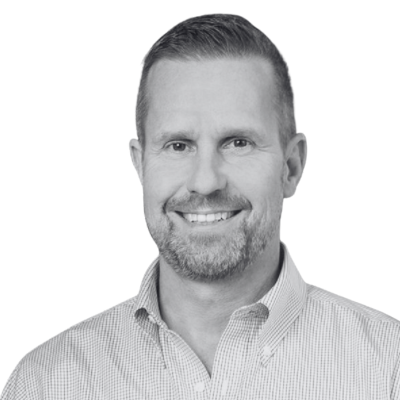 Smiling man in a light checkered button-down shirt on a plain white background