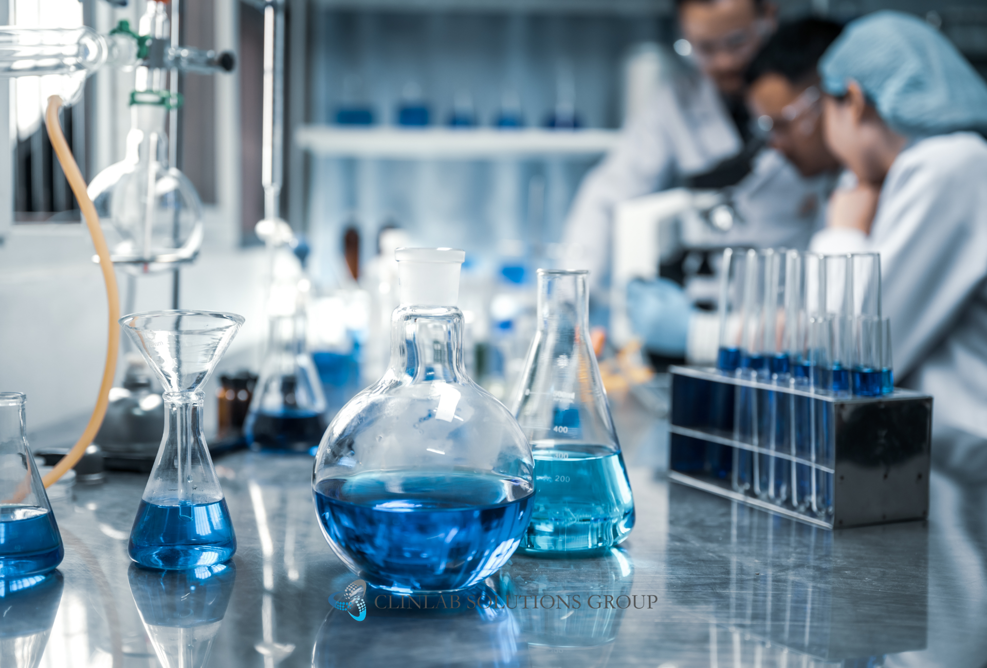 Scientists working in a laboratory surrounded by beakers and research equipment.