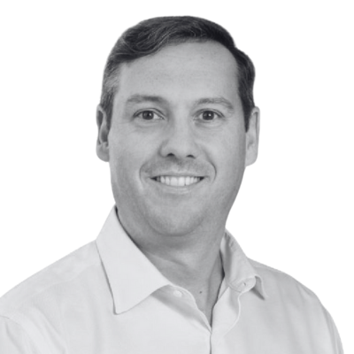Smiling man in a light dress shirt against a plain white background