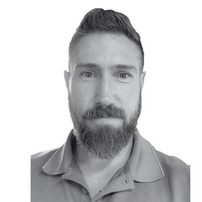 Black-and-white headshot of a bearded man in a collared shirt, facing forward and smiling gently