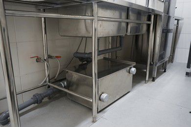 Stainless steel commercial kitchen sink and drain system.