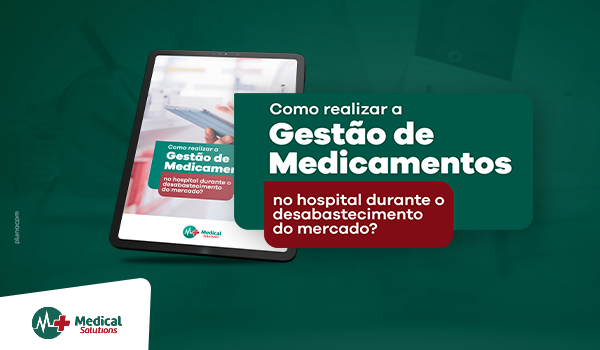 A tablet is sitting on a table next to a book titled como realizar a gestão de medicamentos